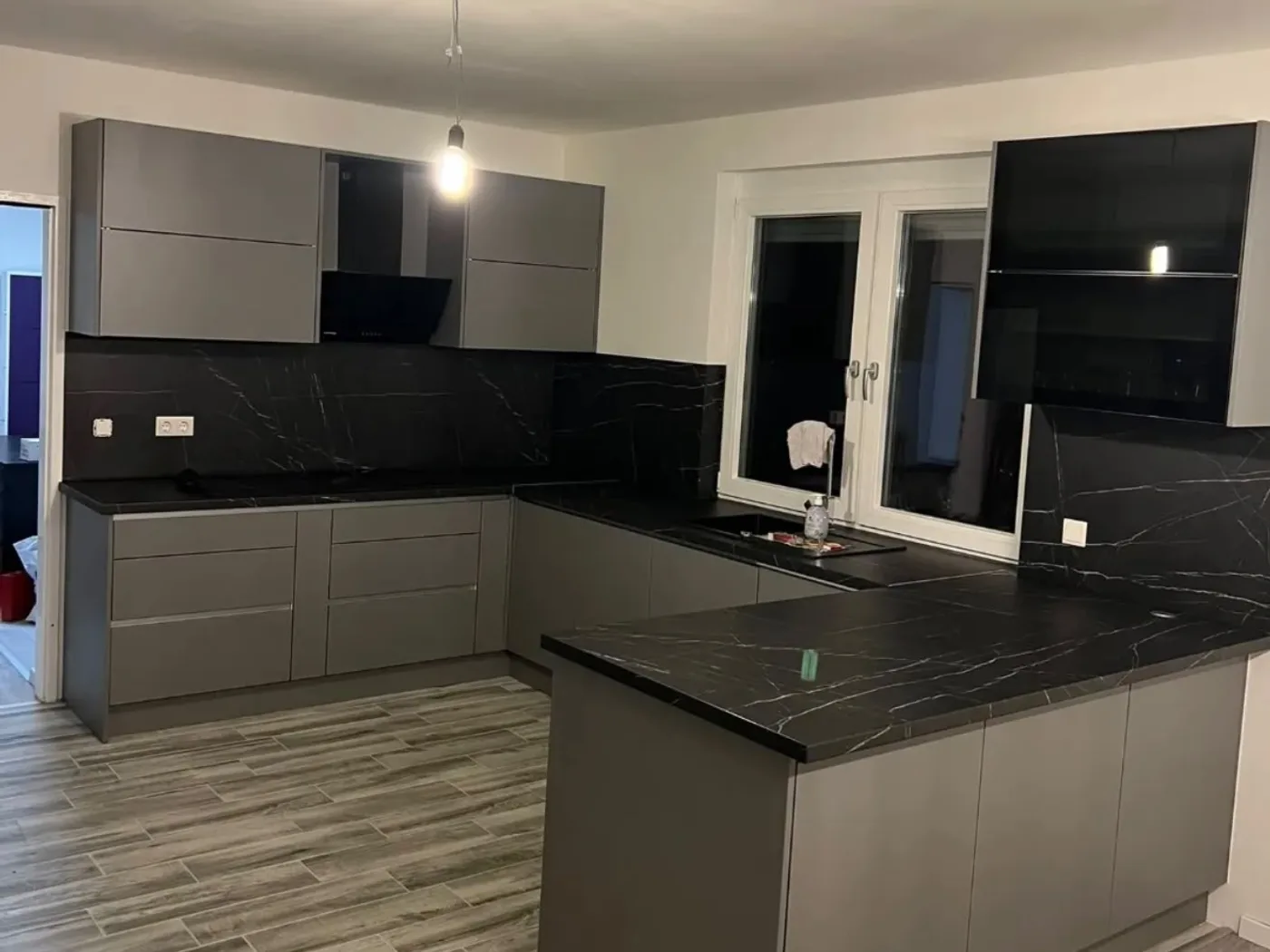 Handleless anthracite kitchen run with black stone worktop