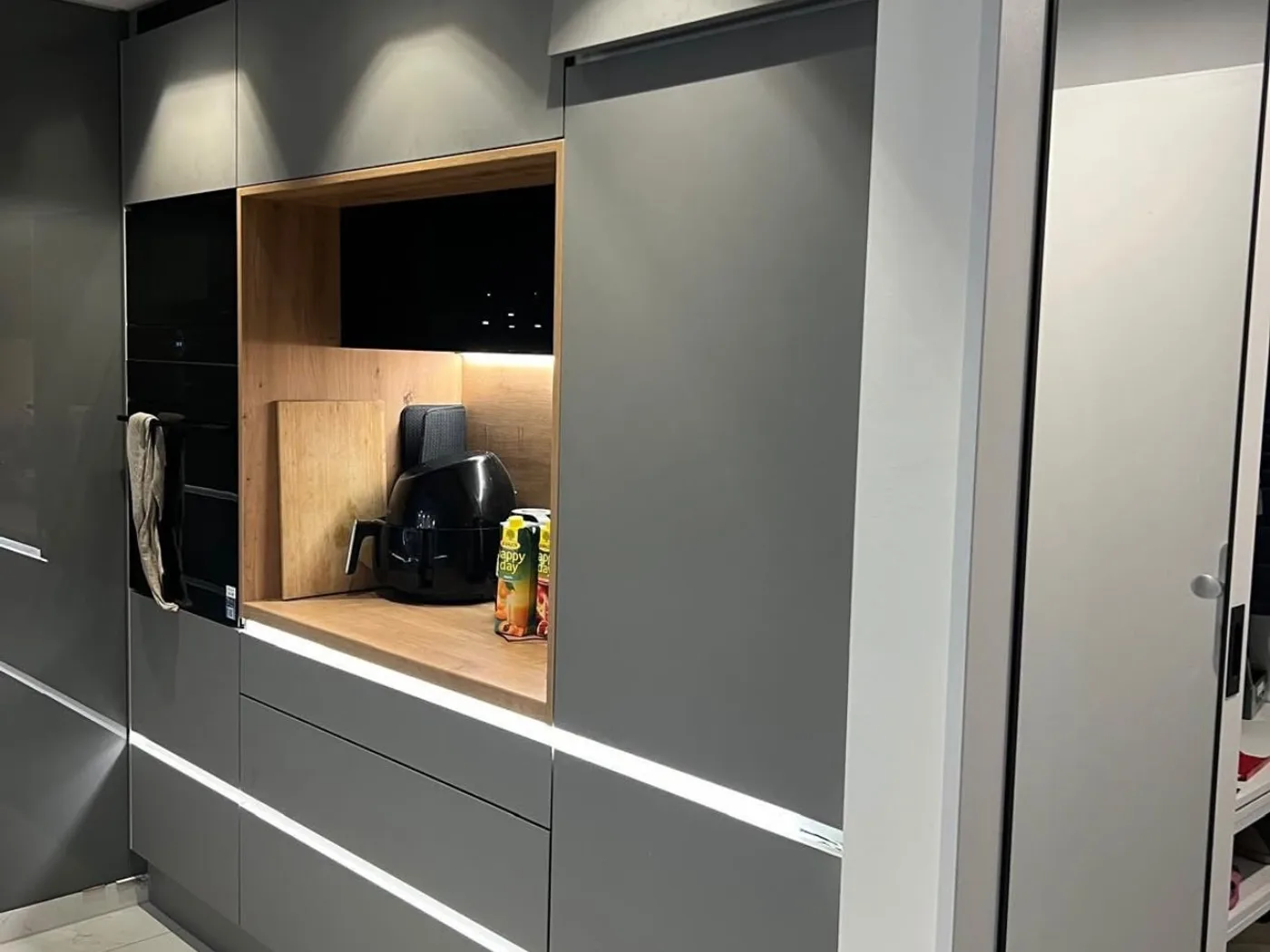 Grey tall-unit run with an open oak niche